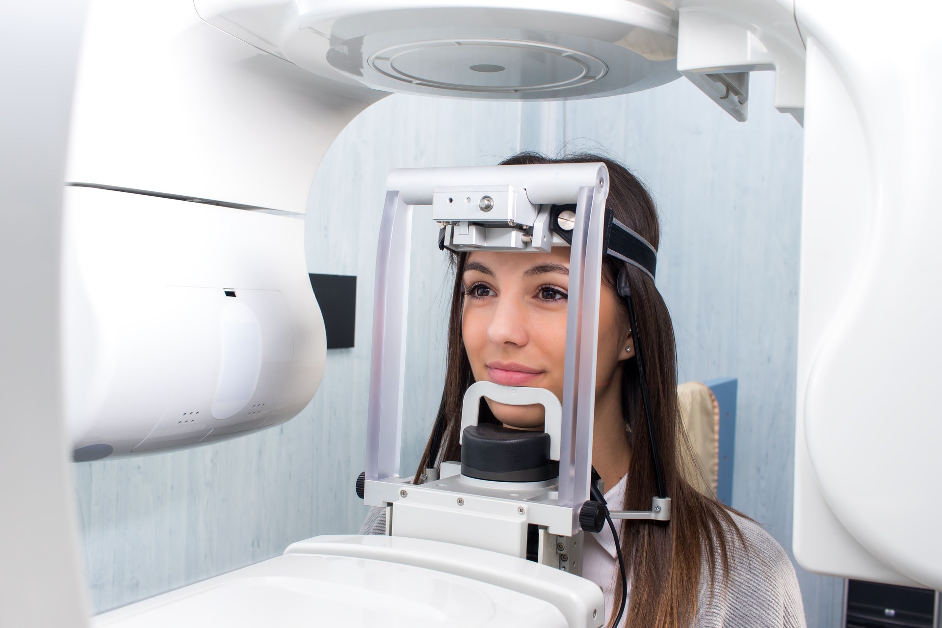 Chica tomando radiografía dental panorámica 3D digital.